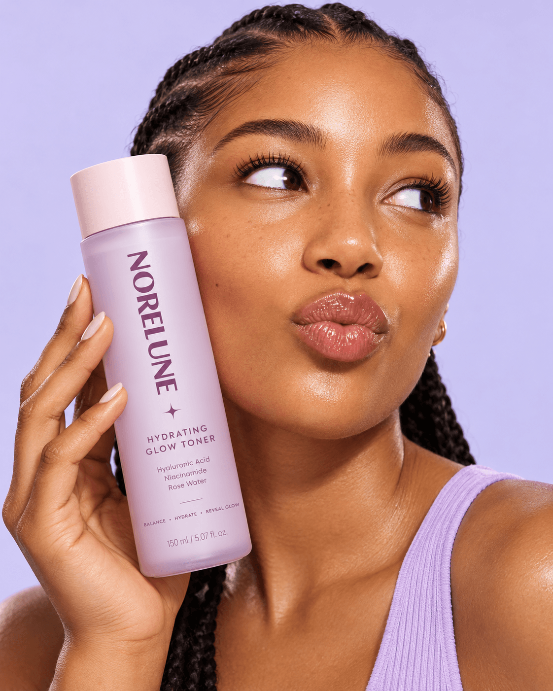 Close-up portrait holding a NoreLune hydrating glow toner against a lavender background